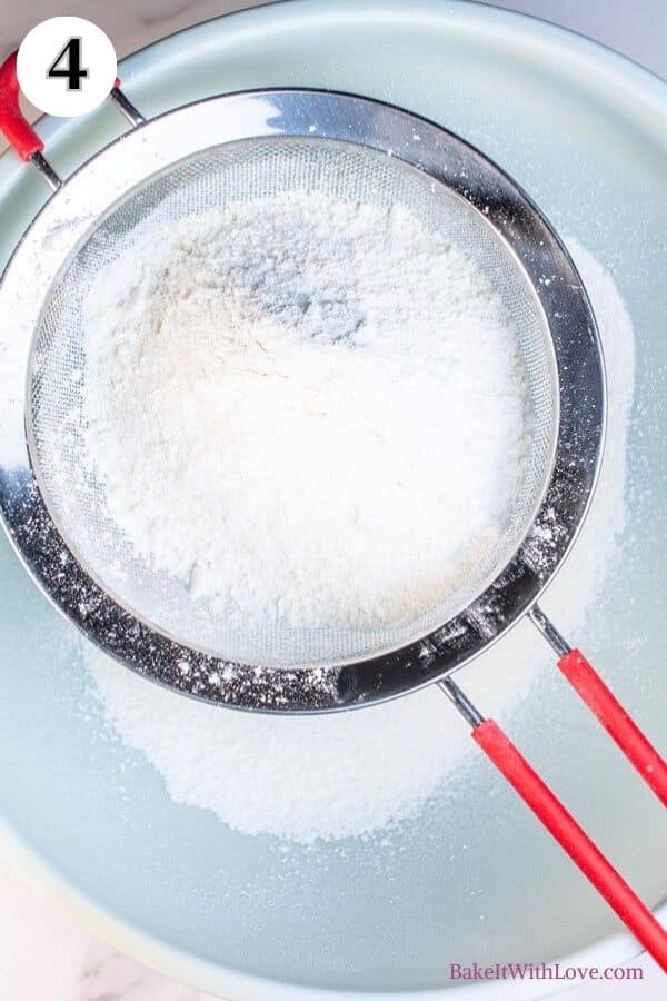 Peppermint macarons process photo 4 showing almond flour and confectioners sugar being sifted through a sieve into a mixing bowl. 