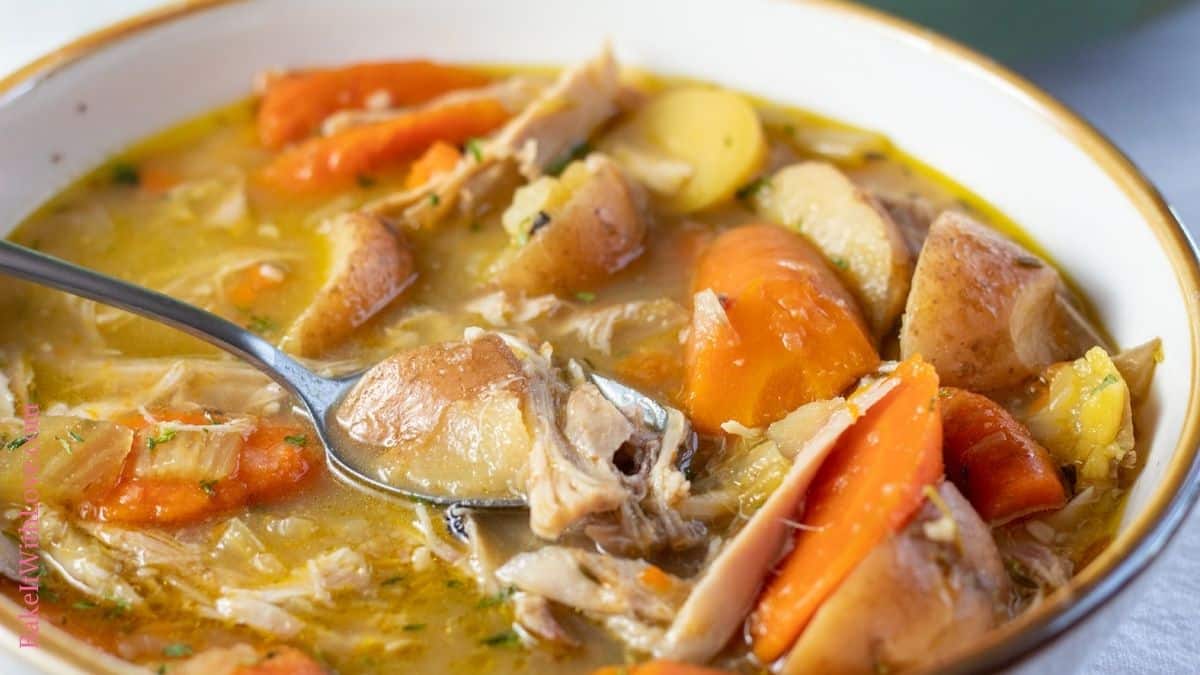 Wide image of a bowl of rabbit stew.