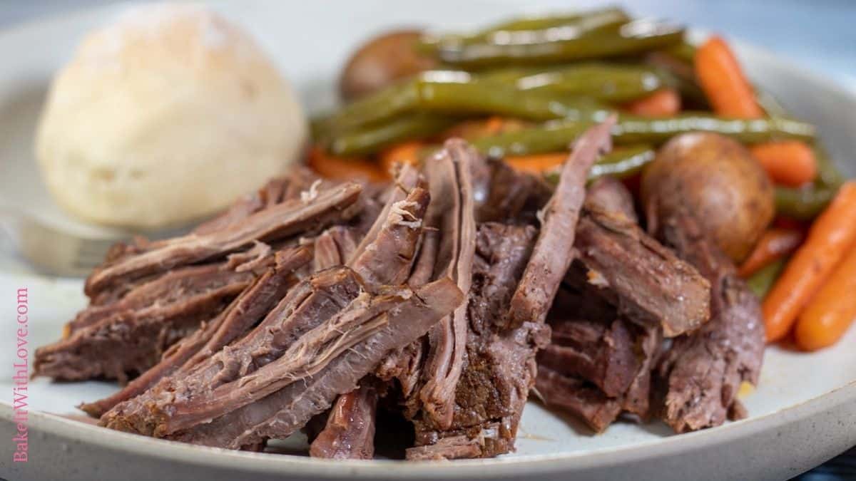 Wide image showing slow cooker London broil on a dinner plate.
