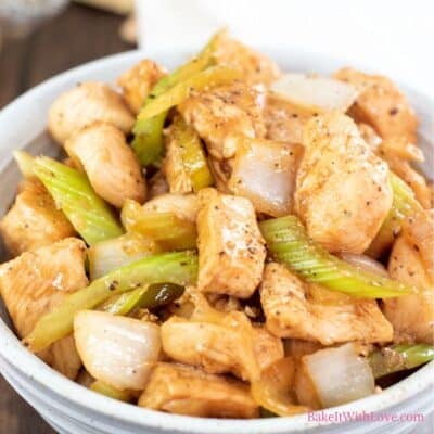 A square image showing a bowl of tender wok fried marinated chicken with celery, onions, and black pepper sauce.