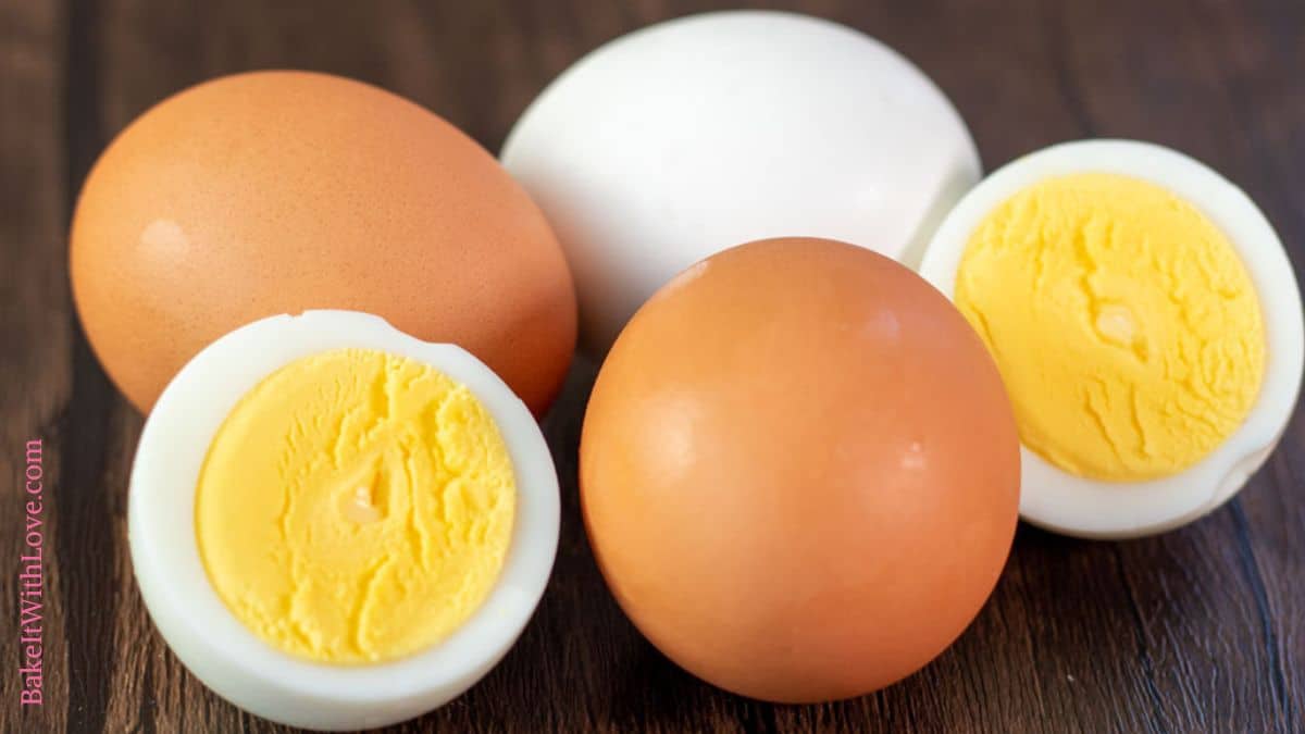 Delicious perfectly cooked air fryer hard-boiled eggs with creamy yolk on dark wooden surface.