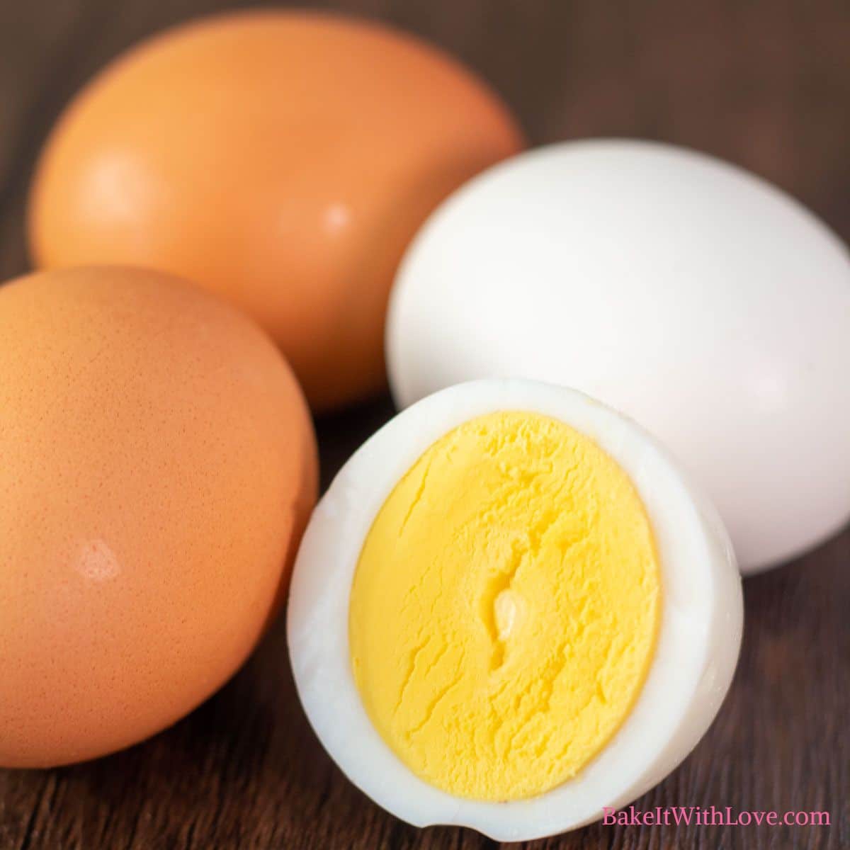 Best air fryer hard boiled eggs recipe featuring white and brown eggs after cooking them, with a couple peeled and sliced in half showing the cooked yolk.