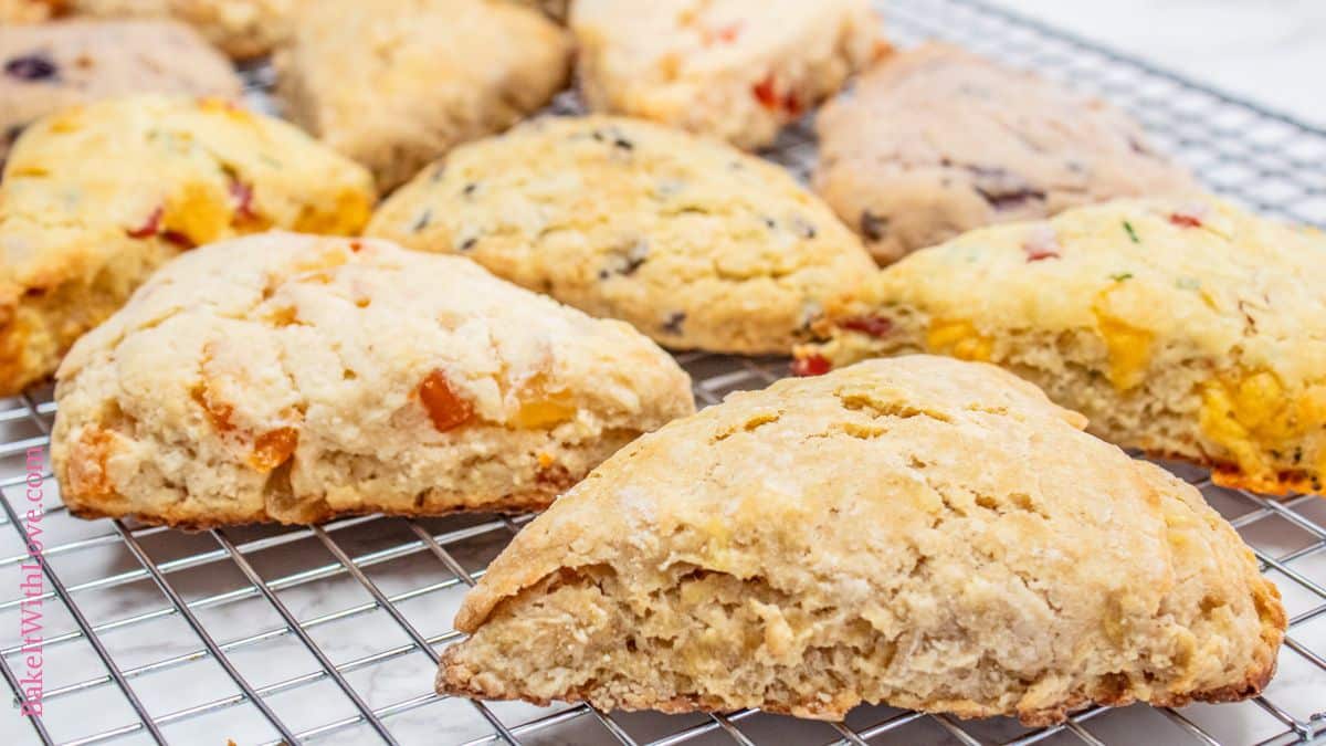 Perfectly baked scones on a wire cooling rack showing all 5 flavors that the master recipe was used for this batch.
