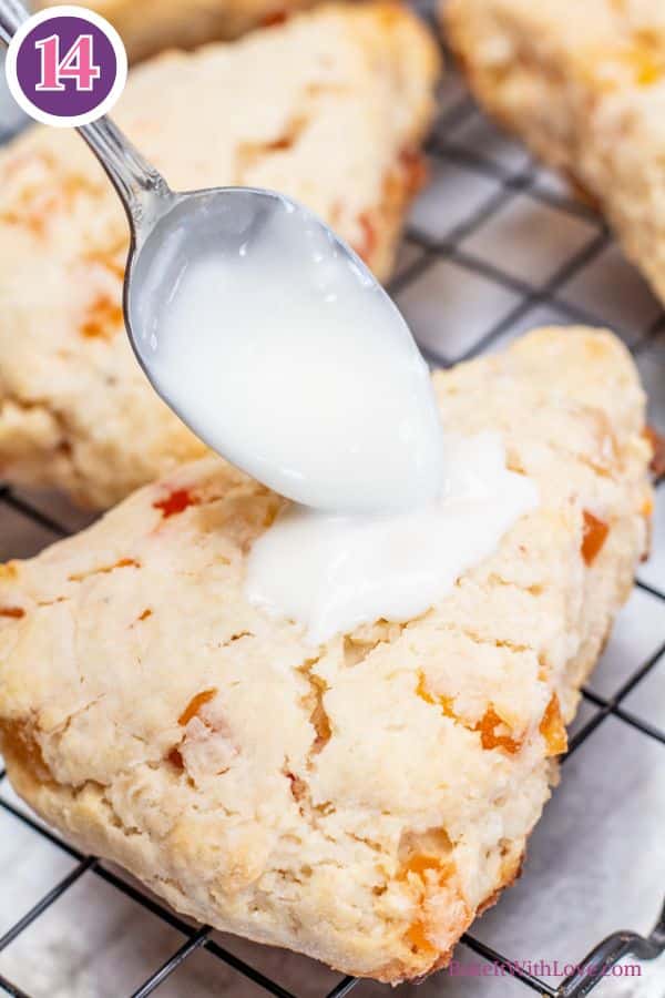 Tropical fruit scones process photo 11 icing being spooned onto baked scone.