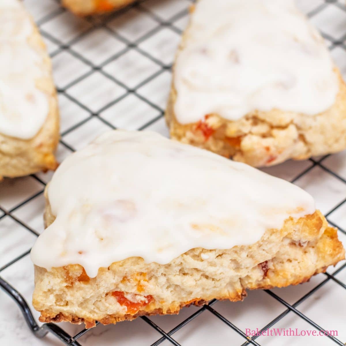 Tropical fruit scones with sweet shredded coconut on the wore rack with the icing setting.
