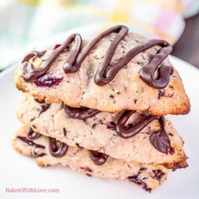 Easy cherry chocolate chip scones stacked on a white plate.
