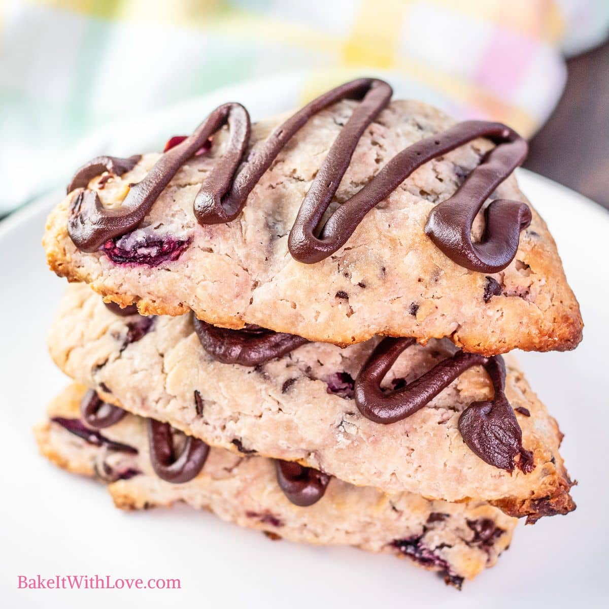 Easy cherry chocolate chip scones stacked on a white plate.