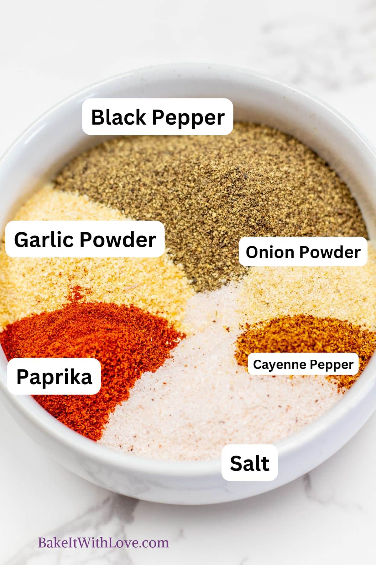 Seasoned salt ingredients, with each spice added in the bowl so you can see them individually and labeled.