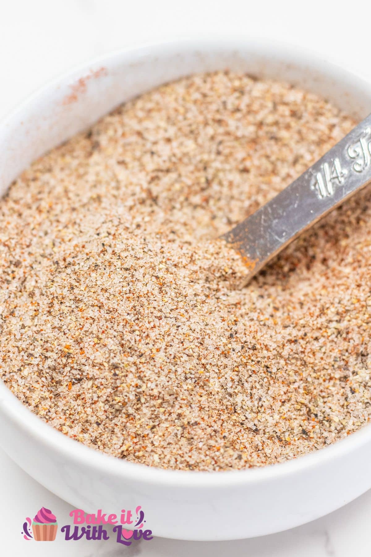 Closeup on the fully combined seasoned salt with the spices evenly distributed in the small white bowl.