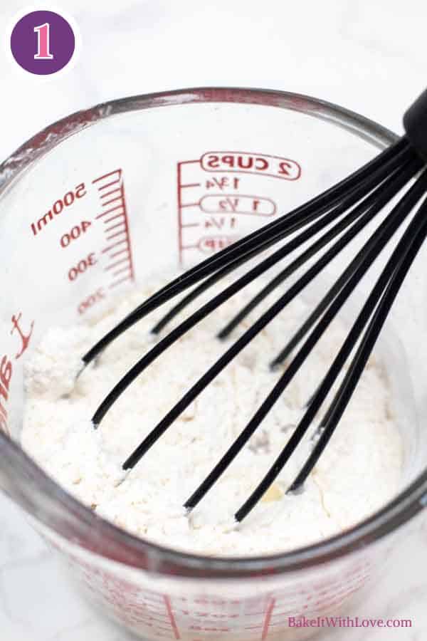 Ham gravy process photo 1 showing the flour, salt, and pepper whisked together in a glass measuring cup.