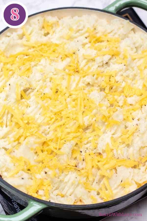 Hamburger pie casserole process photo 8 showing the mashed potato topped casserole with added shredded cheddar cheese on top.