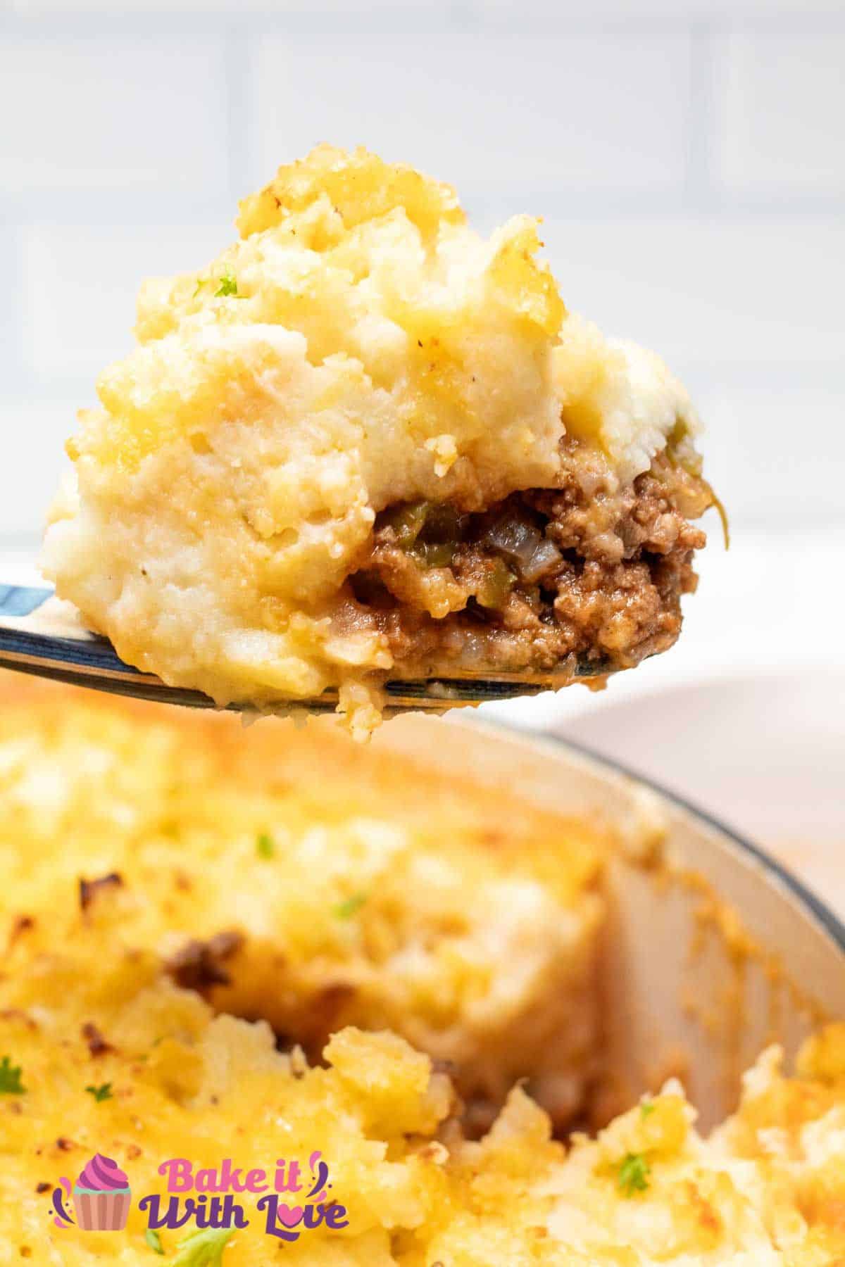 Rich and hearty hamburger pie casserole being scooped from the baking dish for serving.
